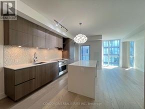 Toronto (Annex) condo for rent - A modern kitchen with a sink, cabinets, and a dining table.