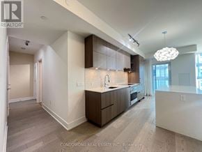Toronto (Annex) condo for rent - A modern kitchen with wood flooring and a large island.