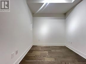 Toronto (Annex) condo for rent - A room with a wooden floor and white walls.