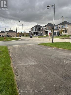Adjala-Tosorontio (Colgan) apartment for rent - A street view of a residential area with houses and a sign for HomeLife Miracle Realty LTD.