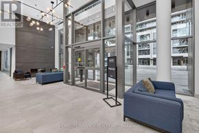 Milton (Tm Timberlea) condo for rent - A modern living room with a blue couch and a glass door leading to a balcony.