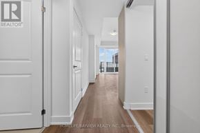 Milton (Tm Timberlea) condo for rent - A hallway with white walls and wooden floors leading to a balcony.