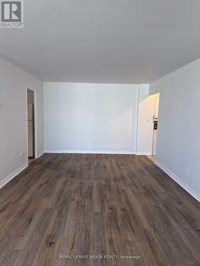 Toronto (Crescent Town) condo for rent - A room with wooden flooring and white walls.