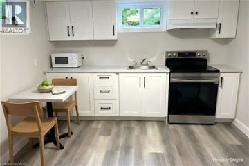 Grimsby apartment for rent - A kitchen with white cabinets and a wooden table.
