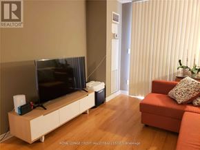 Mississauga (City Centre) condo for rent - A living room with a television on a cabinet and a red couch.
