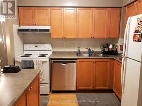 Mississauga (City Centre) condo for rent - A kitchen with wooden cabinets and a white stove top oven.