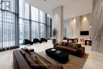 Mississauga (City Centre) condo for rent - A living room with a brown leather couch and a black coffee table.