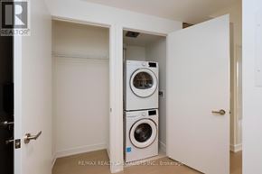 Mississauga (City Centre) condo for rent - A small laundry room with a washer and dryer stacked on top of each other.