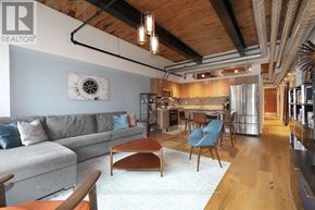 Toronto (Niagara) condo for rent - A living room with a grey couch and a wooden coffee table.