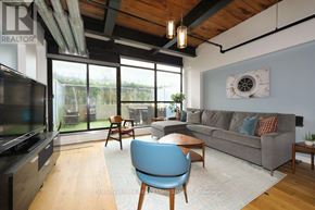 Toronto (Niagara) condo for rent - A living room with a grey couch and a blue chair.