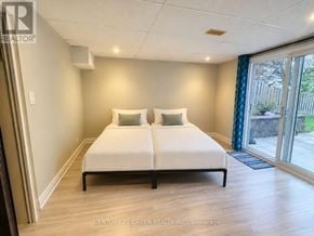 Oshawa (Mclaughlin) apartment for rent - A bedroom with a white bed and wooden floors.