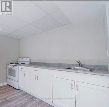 Oshawa (Mclaughlin) apartment for rent - A kitchen with white cabinets and a stove top oven.