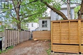 Toronto (South Riverdale) apartment for rent - A backyard with a wooden fence and a tree.