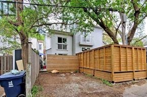 Toronto (South Riverdale) apartment for rent - A backyard with a wooden fence and a blue trash bin.