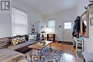 Toronto (South Riverdale) apartment for rent - A living room with a brown couch and a wooden coffee table.