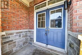 Newmarket (Glenway Estates) townhouse for rent - A blue door with a glass window is set in a brick wall.