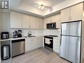 Brampton (Bram East) townhouse for rent - A kitchen with white cabinets and a stainless steel refrigerator.