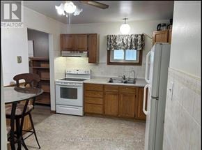 Kawartha Lakes (Lindsay) apartment for rent - A kitchen with a table and chairs in the foreground and a refrigerator in the background.