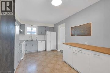 Kitchener apartment for rent - A kitchen with white cabinets and a wooden counter top.