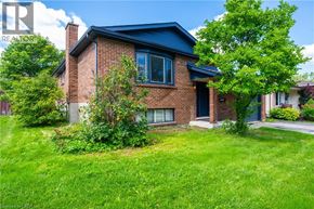 Kitchener apartment for rent - A house with a blue roof and a green lawn in front.