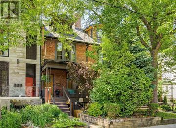 Toronto (University) apartment for rent - A house with a red door is surrounded by greenery.
