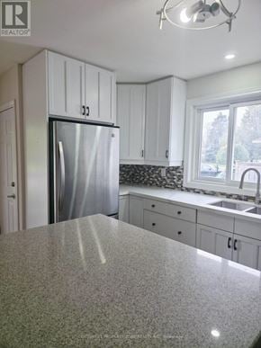 Burlington (Appleby) apartment for rent - A kitchen with granite countertops and white cabinets.