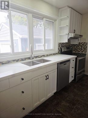 Burlington (Appleby) apartment for rent - A kitchen with white cabinets and a black and white tiled backsplash.