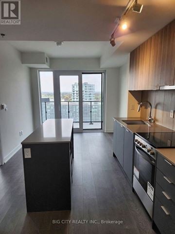 Toronto (Clanton Park) condo for rent - A kitchen with a black countertop and stainless steel appliances.