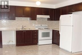 Markham (Cornell) apartment for rent - A kitchen with white appliances and brown cabinets.