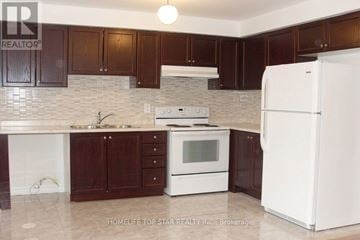 Markham (Cornell) apartment for rent - A kitchen with white appliances and brown cabinets.