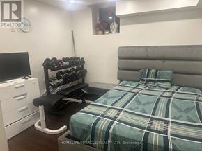 Brampton (Credit Valley) apartment for rent - A bedroom with a bed, a desk, and a weight rack.