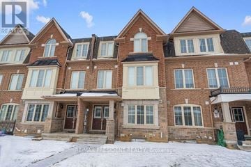 Brampton (Northwest Brampton) townhouse for rent - A large, multi-story brick house with a snow-covered front yard.
