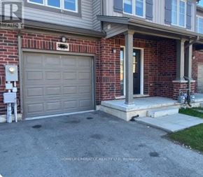 Niagara Falls (Oldfield) townhouse for rent - A house with a garage door and a brick wall.