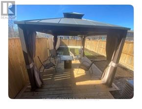 Niagara Falls (Oldfield) townhouse for rent - A patio with a gazebo and chairs is shown in the image.