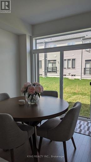 Shelburne townhouse for rent - A table with chairs and flowers on it in front of a window.