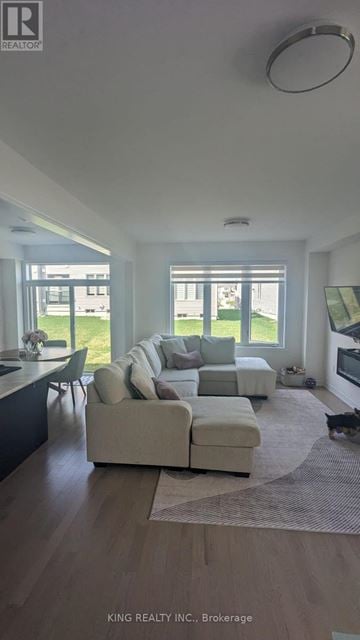 Shelburne townhouse for rent - A modern living room with a large sectional sofa and a kitchen area in the background.
