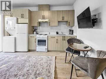 Burnaby apartment for rent - A modern kitchen with a refrigerator, stove, and microwave.