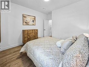 Burnaby apartment for rent - A bedroom with a bed, dresser, and painting.