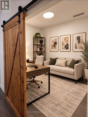 Barrie (Painswick South) condo for rent - A room with a wooden door, a couch, a desk, and some plants.