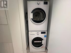 Toronto (Bay Street Corridor) condo for rent - Two white front loading washing machines in a small space.