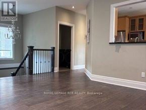 Caledon apartment for rent - A spacious room with wooden flooring and a staircase.
