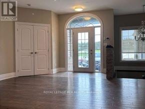 Caledon apartment for rent - A room with a wooden floor and a large arched window.