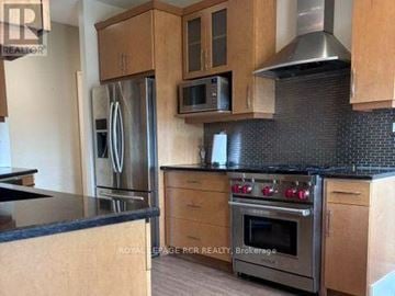 Caledon apartment for rent - A kitchen with wooden cabinets and a stainless steel refrigerator.
