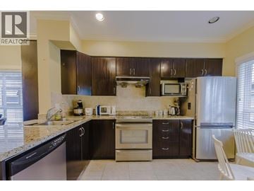 Richmond townhouse for rent - A kitchen with a black dishwasher and stove top oven.