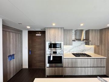 Surrey apartment for rent - A modern kitchen with a dark wood finish and stainless steel appliances.
