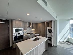 Surrey apartment for rent - A modern kitchen with a marble countertop and stainless steel appliances.