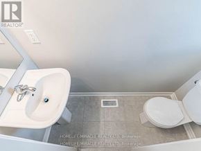 Hamilton (Ryckmans) townhouse for rent - A bathroom with a sink, toilet, and a wall-mounted mirror.