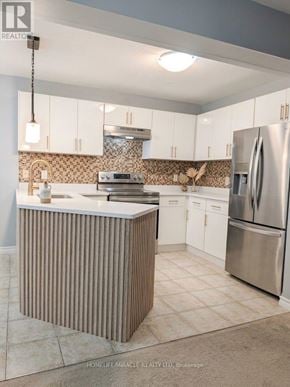 Guelph (Grange Road) apartment for rent - A kitchen with a refrigerator, sink, and cabinets.