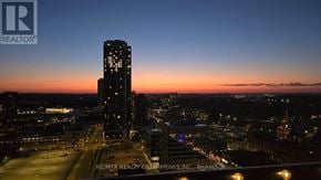 Kitchener condo for rent - A cityscape at dusk with a prominent building in the foreground.