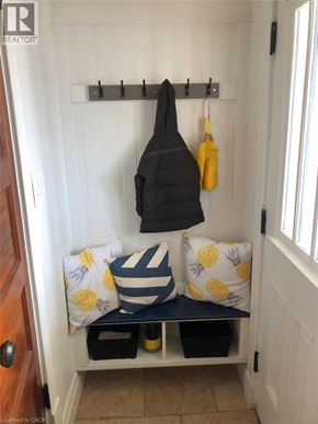 London apartment for rent - A black and yellow towel hangs on a rack above a bench with a striped cushion.